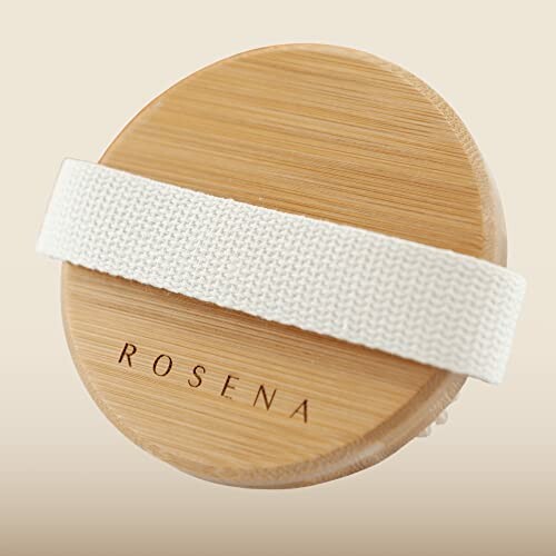 Round bamboo body brush with a white strap.